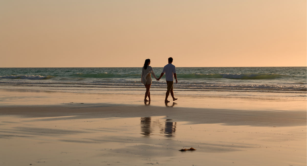 Pictures of a couple walking along Cable Beach