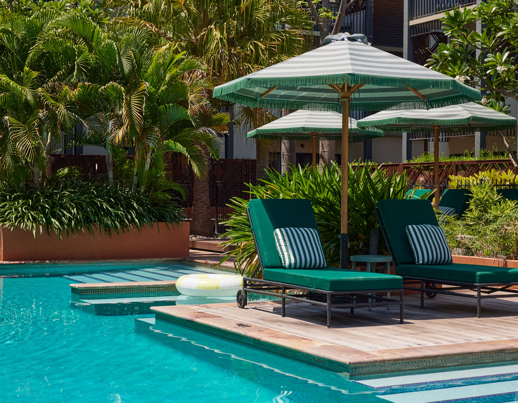 Image of Pinctada Hotel's pool area with umbrellas